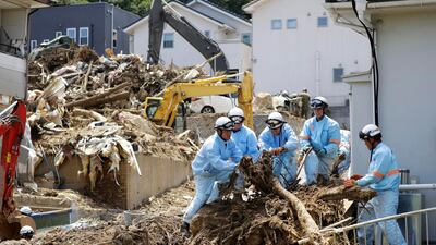 Rescuers remove driftwood from a residential area after flooding caused by heavy rains hit Kumano town, Hiroshima prefecture, southwestern Japan, Thursday, on July 12, 2018. Kyodo News via AP
