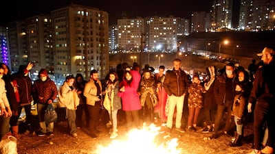 People gather round a bonfire during Charshanbeh Suri fire festival celebrations, in Tehran. EPA