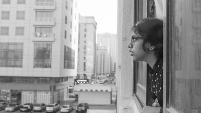 Vidhyaa Chandramohan's daughter looks outside the window of their Abu Dhabi flat. Vidhyaa Chandramohan