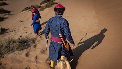 Archers set off through the desert to score and collect the arrows in the long-distance segment of the competition
