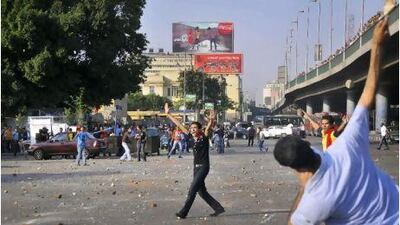 In this file photo from Sunday, May 8, crowds rampage through the streets of Cairo, in renewed sectarian violence, as various groups of Christians and Muslims throw rocks at each other during clashes near the city centre in Cairo, Egypt.