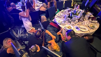 Guests take cover after gunshots were heard at the White House Correspondents' dinner. Reuters