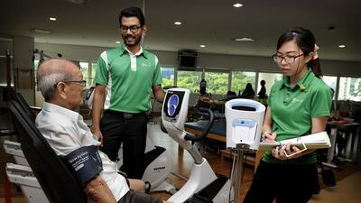 In Singapore, paying for health care is the shared responsibility of the government and individuals. Staff nurses of Ren Ci seen here attending to a patient during rehab excercises.