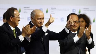 French foreign minister and president of the COP21 Laurent Fabius, center, applauds while United Nations secretary general Ban Ki-moon, left, and French president Francois Hiollande applaud after the final conference of the COP21, the United Nations conference on climate change. Francois Mori / AP Photo