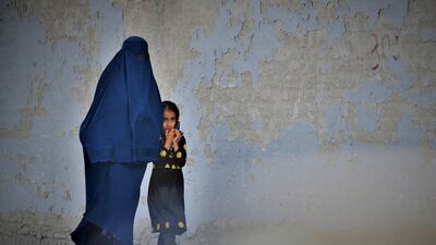 A woman walks with a girl along a street in Kabul on May 7. AFP