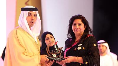 Sheikh Mansour presents her award to Vandana Marwaha, principal of Delhi Private School in Sharjah. Pawan Singh / The National
