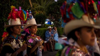 Abel Aguilar, center left, and his wife attend the celebration marking the birth of the Paricutin volcano, in San Juan Nuevo Parangaricutiro, Mexico, Monday, Feb. 20, 2023. Aguilar was 5-years-old when the Paricutin erupted for the first time. He would come with other children to “see the lava walk like that, real slow. ” He said. (AP Photo / Eduardo Verdugo)