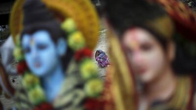 A woman sits next to the idols of Hindu deities on the banks of the river Yamuna in New Delhi. Adnan Abidi / Reuters