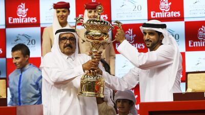 Sheikh Hamdan Bin Rashid Al Maktoum is presented with the Dubai World Cup trophy in 2015 after Prince Bishop won the showpiece race. Pawan Singh / The National