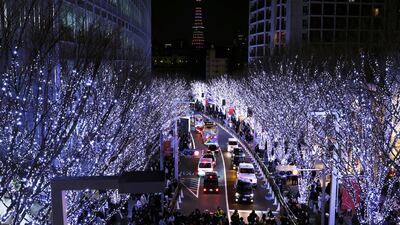 People walk through an illuminated street in Tokyo on Christmas Eve. AP