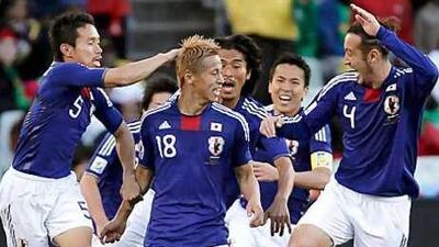 Japan's Keisuke Honda, front centre, celebrates his goal with teammates.