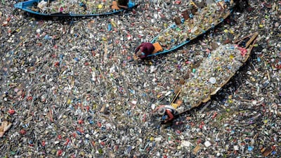 People on boats collect recyclable plastics from the heavily polluted Citarum River at Batujajar in Bandung, West Java. AFP