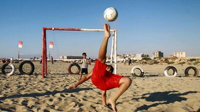 A boy kicks a ball while shooting at a football net along a beach in Libya's eastern coastal city of Benghazi. AFP