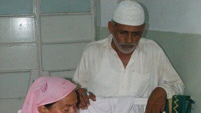 Pakistani relatives stand next to an acid victim as he treated at a hospital in Multan. SS Mirza / AFP Photo