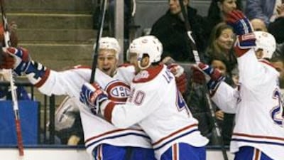 Montreal Canadiens Guillaume Latendresse (left) celebrates his first period goal against the Toronto Maple Leafs with team mates Maxim Lapierre (centre) and Josh Gorges.