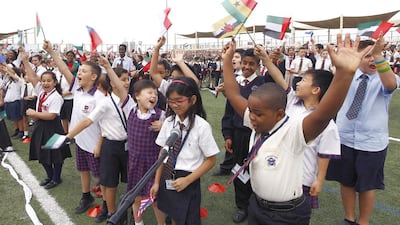 Gems pupils and staff celebrate after breaking the Guinness World Record for the largest number of nationalities singing a national anthem at the same time in 2014. About 100,000 pupils and staff from across the school network took part. Jeffrey E Biteng / The National