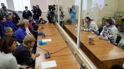 Nick Hague and Alexey Ovchinin speak with their relatives through a safety glass prior to the launch. AP Photo