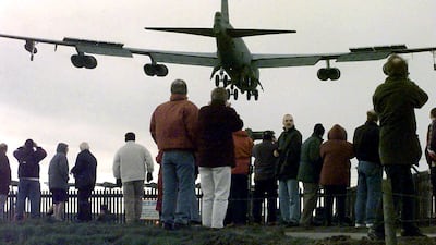 Residents watch a giant American B-52 bomber arrive at the RAF Fairford air base near Cirencester, Gloucestershire, February 21, 1999 as part of the NATO military build-up over Kosovo.AFP