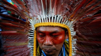 An indigenous man wearing a feathered headdress attends a climate change protest march, as COP25 climate summit is held in Madrid, Spain. Reuters