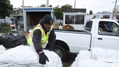 A San Francisco Department of Public Works worker loads sandbags into a lorry. Getty / AFP
