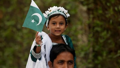 A girl holds a Pakistan flag as she sits on the shoulders of her father during a ceremony to celebrate the country's 70th Independence Day at the mausoleum of Muhammad Ali Jinnah in Karachi. Akhtar Soomro / Reuters