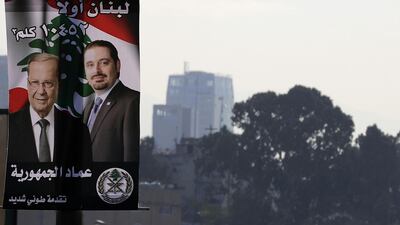A poster of Saad Hariri, who resigned as Lebanon's prime minister, and president Michel Aoun is seen on a street lamp on a highway in the capital Beirut. The Arabic writting on poster reads "Lebanon First". Joseph Eid / AFP