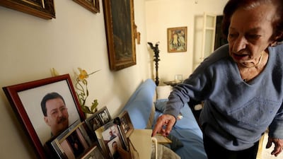 Marie Mansourati, 83, adjusts pictures of her kidnapped son Dani, more than two decades after he was taken by Syrian troops to Damascus, at her house in Beirut on April 8, 2015. Joseph Eid/AFP Photo