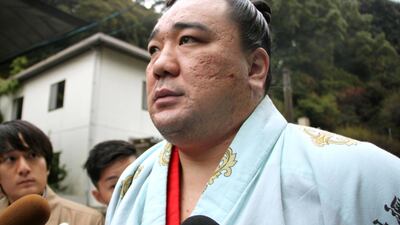 Mongolian sumo grand champion Harumafuji speaks to journalists as investigations begin that he assaulted a rival opponent at a party with a bottle. Kyodo News via AP