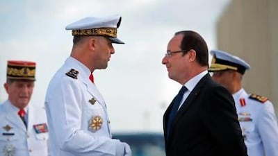 Francois Hollande, the French president, is welcomed by vice admiral Marin Gillier, left, chief of the French troops in the UAE, at the French naval base Camp de la Paix in Abu Dhabi. Bertrand Langlois / AFP