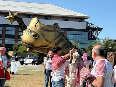 Jordan fans take pictures next to a sculpture of a giant football boot with a Texan spur in Arlington, Texas. Kyle Fitzgerald / The National