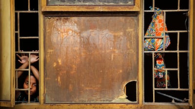 The daughter of a migrant labourer looks out from a quarantine centre in New Delhi where her family was taken while trying to leave for their home village. AP Photo