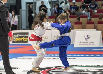 Mariam Akeil, in blue, of Saudi Arabia in her match against England's Daya Dosanjh in their junior girls 25kg white belt bout at the Abu Dhabi Jiu-Jitsu Festival on Friday. Victor Besa / The National