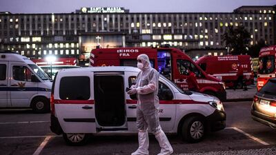 A health worker wearing a protective suit walks past dozens of ambulances waiting outside the Covid-19 emergency services of Santa Maria Hospital in Lisbon. Portugal reported twin Covid records with 303 new deaths and 16,432 cases in a 24-hour period, prompting a decision to limit foreign travel to "special cases". AFP