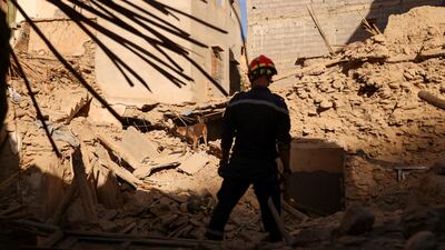 An emergency worker and a dog search for bodies in the rubble in Amizmiz, Morocco. Reuters