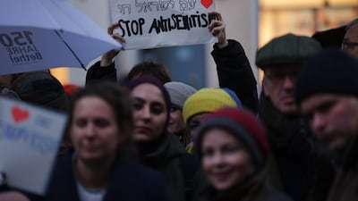 A demonstrator holds a sign saying 'Stop anti-Semitism' at a vigil in Berlin on Friday after attackers hurled Molotov cocktails at a synagogue in the German capital. Getty Images
