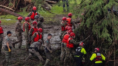 Search and recovery workers dig through debris looking for any survivors or remains of people swept up in the flash flooding at Camp Mystic on Sunday in Hunt, Texas. AFP