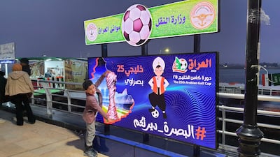Ibrahim Mohammed poses next to a hoarding in Basra promoting the Gulf Cup, featuring Sinbad the Sailor, the mascot for the tournament. All photos: Sinan Mahmoud / The National