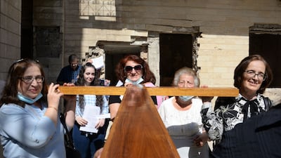 Iraqi christians carry a large cross during the inauguration ceremony for a new bell at a church in the country's second city of Mosul. AFP