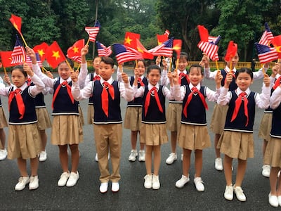 Children wave American and Vietnamese flags as they wait for President Donald Trump to arrive for a meeting with Vietnamese President Nguyen Phu Trong in Hanoi. AP