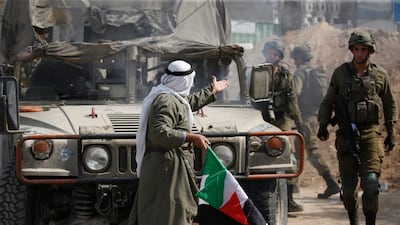 A man holds a Palestinian national flag during a protest to remove an earth wall blocking the west entrance of the occupied West Bank city of Nablus. EPA