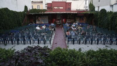 Moviegoers take their seats in front of hand- painted posters of the 1968 musical drama Oliver! starring Mark Lester and the 1966 western El Dorado starring John Wayne and Robert Mitchum, at the Zefyros vintage-movie cinema in Ano Petralona, near central Athens. Most Greeks watch movies outdoors during the summer, but businesses are under threat from the country’s financial crisis and cost of switching to digital projection.