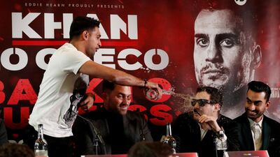 Amir Khan throws water into the face of Phil Lo Greco during the press conference as promoter Eddie Hearn looks on. Andrew Boyers / Reuters