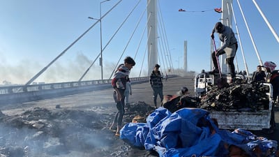 Iraqi demonstrators clean the rubbish of burned tents, which were destroyed last night during the ongoing anti-government protest in Nassiriya, Iraq. Reuters