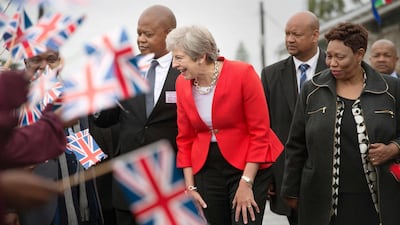 Theresa May is greeted by schoolchildren during a visit to the ID Mkhize Secondary School in Gugulethu township, near Cape Town on August 28. Rodger Bosch / AFP
