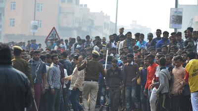 Police personnel try to clear a road as onlookers gather following a factory fire in Anaj Mandi area of New Delhi. At least 43 people have died in a factory fire in India's capital New Delhi. AFP