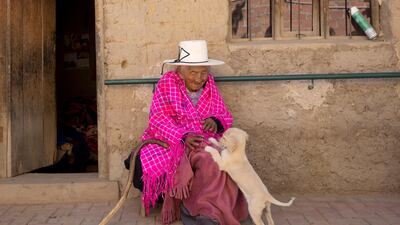 Julia Flores Colque, who is 117 years old and never had children, plays with Chiquita, one of the family pet dogs, at her home in Bolivia. Juan Karita / AP