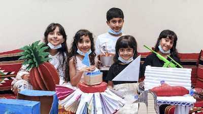 From left to right, Emirati students Noora, Fatima, Ahmed, Meera, and Hind Alzaabi showcase their projects, made through Adnoc's Stem@Home programme. Victor Besa /The National