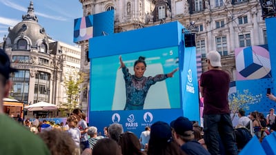 Spectator watch Simone Biles's routine at a fan zone at the Hotel de Ville. AP