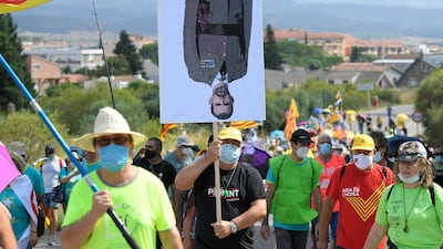 A man carries an upside-down portrait of King Felipe VI of Spain during an anti-monarchy march in Monasterio de Poblet. AFP