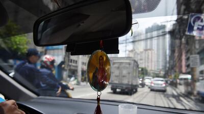 Hanging rosaries and religious icons in vhicles will be banned in the Philippines from May 26. Ted Aljibe / AFP Photo